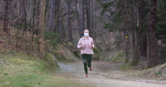 电晕病毒科维德传播世界肖像高加索人运动女人穿医疗保护脸面具运行自然