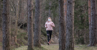 电晕病毒科维德传播世界肖像高加索人运动女人穿医疗保护脸面具运行自然