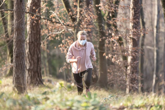 电晕病毒科维德传播世界肖像高加索人运动女人穿医疗保护脸面具运行自然