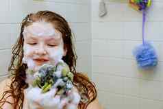 可爱的女孩洗头发洗澡浴泡沫