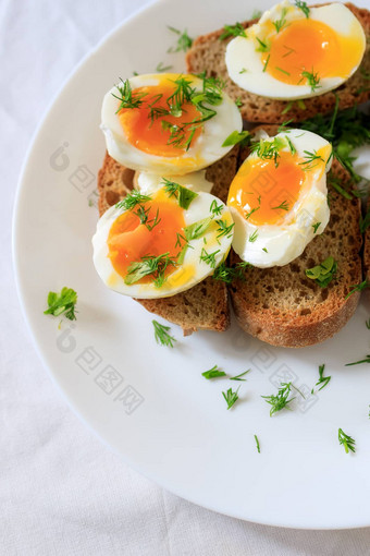 半熟的蛋半莳萝粮食烤面包面包白色板特写镜头前视图健康的健康的健康的早餐概念