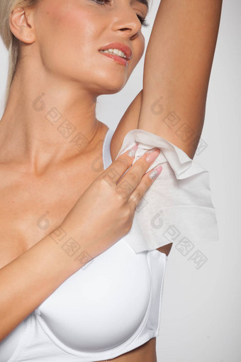 年轻的女人清洁腋窝湿湿巾