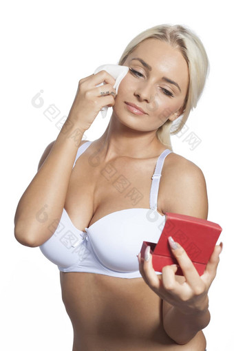 年轻的女人清洁脸<strong>湿湿巾</strong>持有镜子