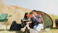 夫妇享受喝前面野营帐篷