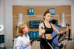 女运动员使物理努力步进持有电极医生持有平板电脑手