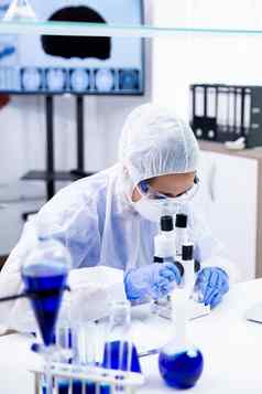 科学家女人保护设备调整显微镜