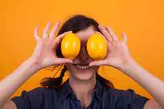 可爱的年轻的女人微笑相机橙子眼睛黄色的背景工作室