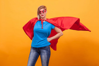 年轻的女人超能英雄服装站自豪地红色的角空气黄色的背景