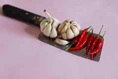 大蒜灯泡红色的辣椒刀粉红色的背景显示概念美食厨房烹饪食物行业