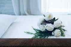 白色新娘婚礼玫瑰花花束床上通过
