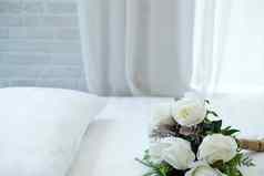 白色新娘婚礼玫瑰花花束床上通过