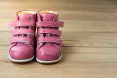粉红色的孩子们鞋子木背景孩子们的皮革靴子