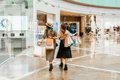 购物娱乐购物中心内部美丽的女孩纸袋购物中心快乐消费礼物购物假期