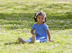 漂亮的微笑年轻的女孩坐着绿色草地阳光明媚的春天一天
