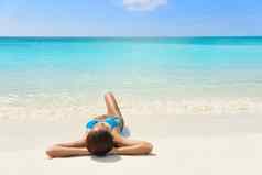 热带加勒比海滩假期晒黑放松女人比基尼女孩说谎放松白色沙子异国情调的目的地睡觉日光浴夏天假期