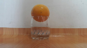 关闭视图橙子白色玻璃木地板上背景