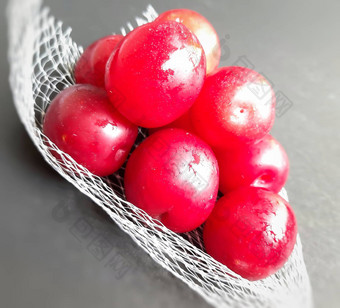 色彩斑斓的红色的李子水果封面黑色的背景减少风险癌症心疾病糖尿病