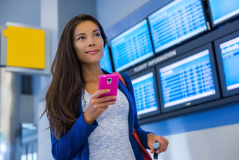 旅行女人智能手机机场年轻的亚洲旅行者检查登机时间移动电话应用程序终端火车站旅游假期