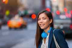 年轻的专业亚洲女人臀部科技设备耳机走纽约纽约城市街通勤工作晚上快乐微笑混血儿中国人年轻的女孩城市生活方式