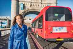 伦敦女人走上下班塔桥城市街公共运输公共汽车通勤早....快乐年轻的亚洲英国业务工人工作旅游城市旅行
