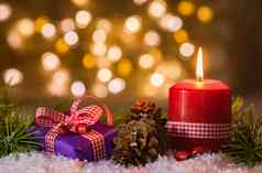 快乐圣诞节装饰出现礼物燃烧红色的蜡烛模糊背景