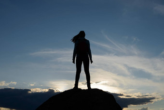 年轻的女人旅行者背包<strong>站前</strong>岩石夏天日落旅行冒险概念