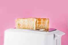 烤烤面包面包白色烤面包机粉红色的背景