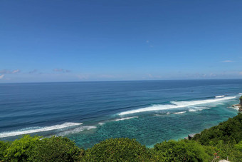 美丽的蓝色的日落海洋大波悬崖悬崖巴厘岛岛热带异国情调的自然日出海海洋幻影蓝色的日落