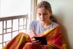 伤心女孩坐着窗口电子书阅读首页孤立的冠状病毒检疫概念