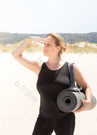 女人运动服装卷起来的席手臂海滩