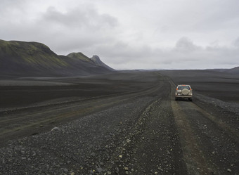 南冰岛自然储备山背7月路车丰田陆地巡洋舰开车脏山路黑色的熔岩沙子沙漠景观绿色山喜怒无常的天空