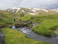 孤独的男人。徒步旅行者走景观野生溪流绿色草莫斯草地雪覆盖rhyolit山地热区域鸵鸟路冰岛自然储备山背