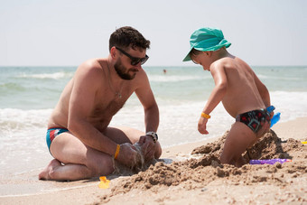 父亲儿子夏天假期玩沙子<strong>海海</strong>滩爸爸孩子享受在一起周末<strong>活动</strong>