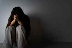 伤心女人拥抱膝盖哭坐着黑暗房间抑郁症不开心强调焦虑障碍概念