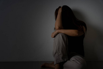 伤心女人拥抱膝盖哭坐着黑暗房间抑郁症不开心强调焦虑障碍概念