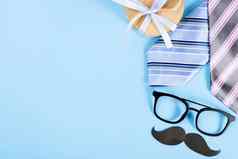 快乐父亲一天背景概念蓝色的领带眼镜礼物盒子黑色的胡子蓝色的背景复制空间文本