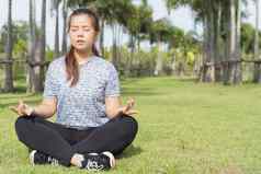 年轻的女人练习瑜伽冥想莲花位置