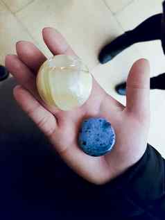女孩持有蓝色的黄色的石头矿物质手