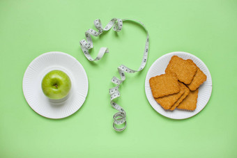 饮食健康的吃概念前视图减肥法选择绿色苹果饼干问题马克测量磁带绿色背景