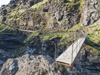 景观木人行桥蓝色的冰川河洛加徒步旅行小道冰岛熔岩形成绿色山山夏天蓝色的天空背景