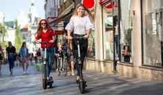 时尚的轻轻松松少年女孩骑公共租赁电摩托车城市城市环境环保现代公共城市运输卢布尔雅那斯洛文尼亚