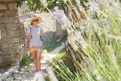 美丽的金发女郎年轻的女旅行者穿稻草太阳他观光享受夏天假期传统的村地中海成本