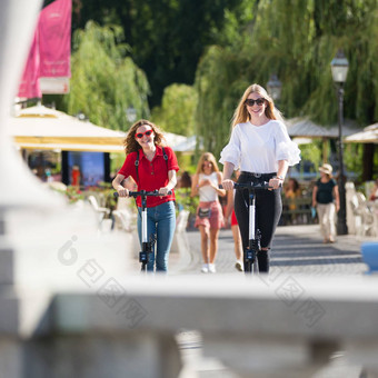 时尚的轻轻松松少年女孩骑公共租赁电摩托车城市城市环境环保现代公共城市运输卢布尔雅那斯洛文尼亚