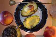 食物作文鳄梨半板扭曲的勺子成熟的桃子古董铜杯大叶茶椰子