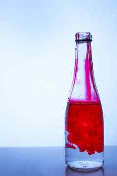 红色的墨水混合水玻璃瓶光背景