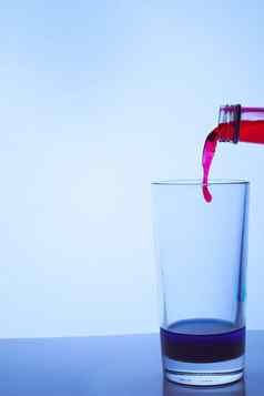 红色的酒倒玻璃玻璃蓝色的液体