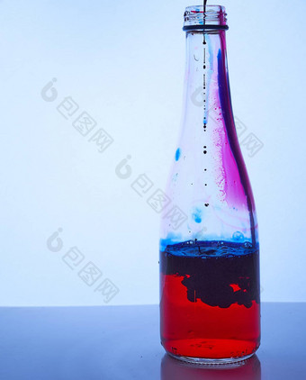 蓝色的墨水滴内部玻璃瓶红色的液体混合效果