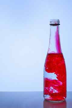 红色的墨水混合水玻璃瓶光背景