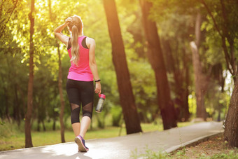美丽的健身运动员跑步者女人喝水公园水瓶
