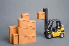 黄色的叉车卡车提出了纸板盒子前堆栈桩盒子仓库股票商务零售电子商务出售货物在线交易运费航运交付
